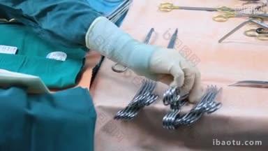 戴手套的手拿消毒手术器械的特写，擦洗护士准备手术器械